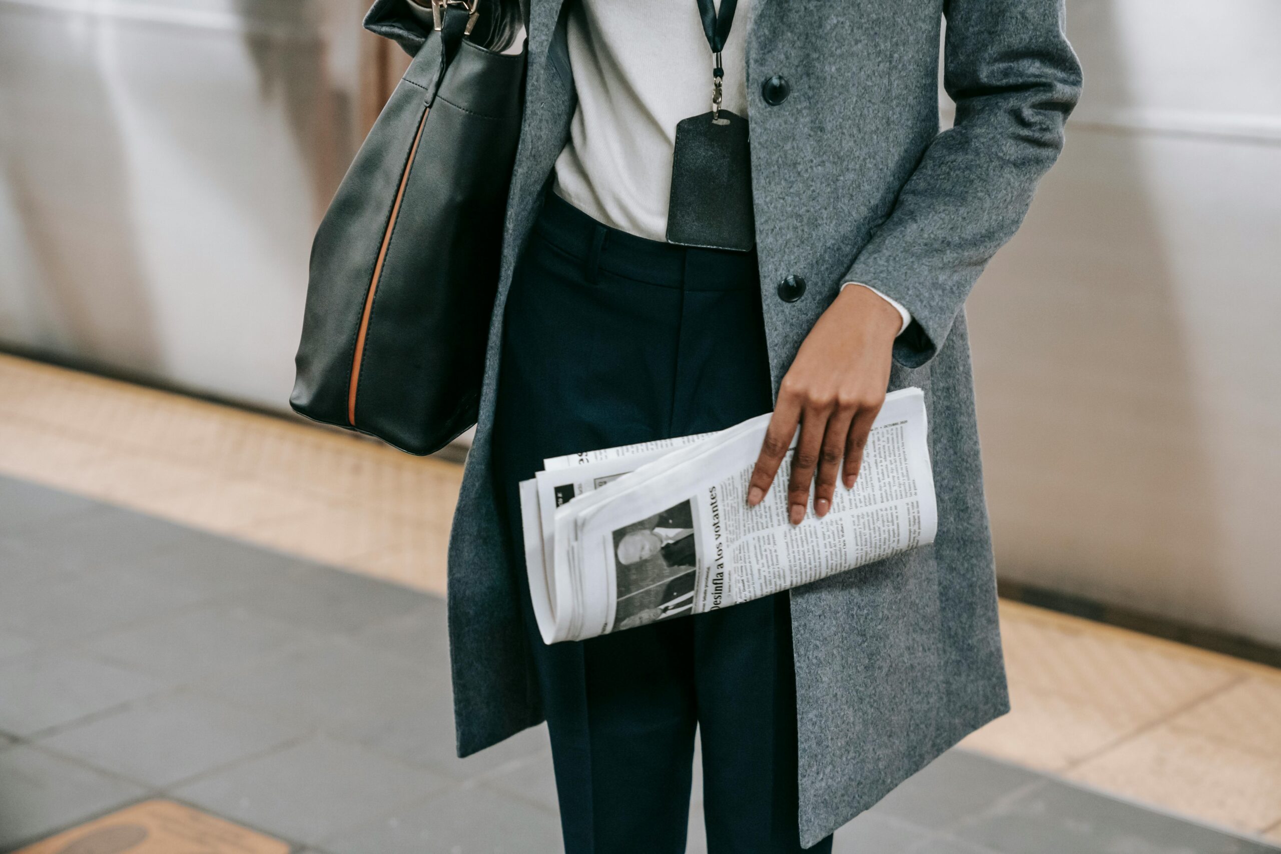 woman holding newspaper commuting to work